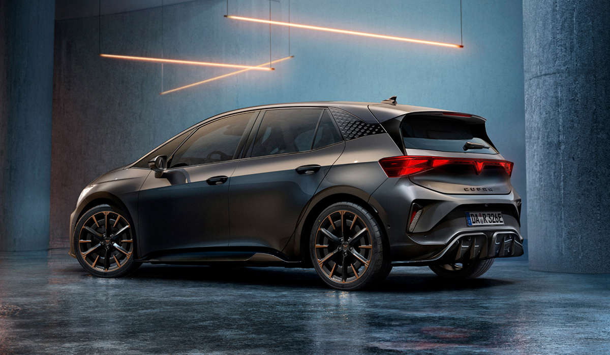 CUPRA Born in Blau auf einem Parkdeck vor beleuchteten Hochhäusern